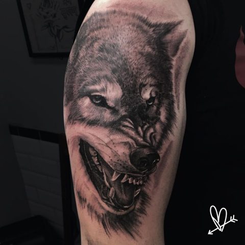Tattoo mit knurrendem Wolf auf der Schulter