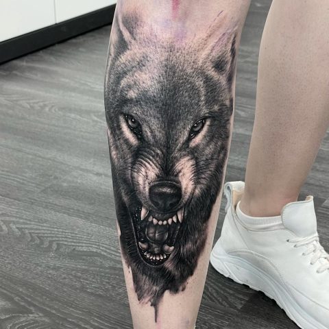 Großes schwarzes Wolf-Tattoo am Fuß
