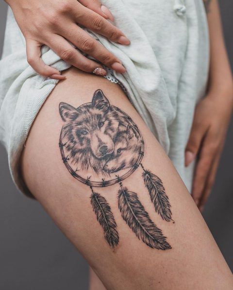 Wolf- und Traumfänger-Tattoo auf dem Oberschenkel
