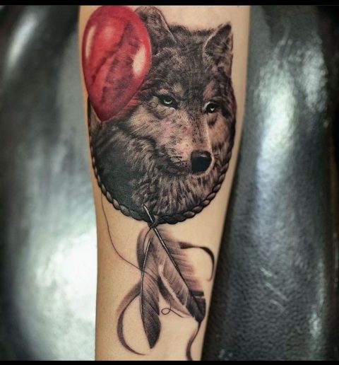 Tatuaż z wilkiem i piórkiem