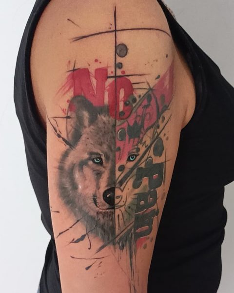 Tatuaże z wilkiem i cytatem
