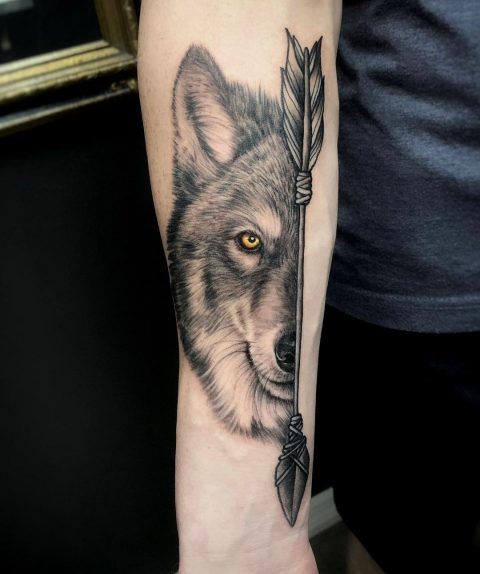 Wilk ze strzałą tatuażem
