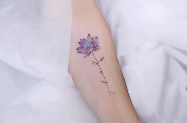 mały tatuaż z kwiatem lotosu dla kobiety